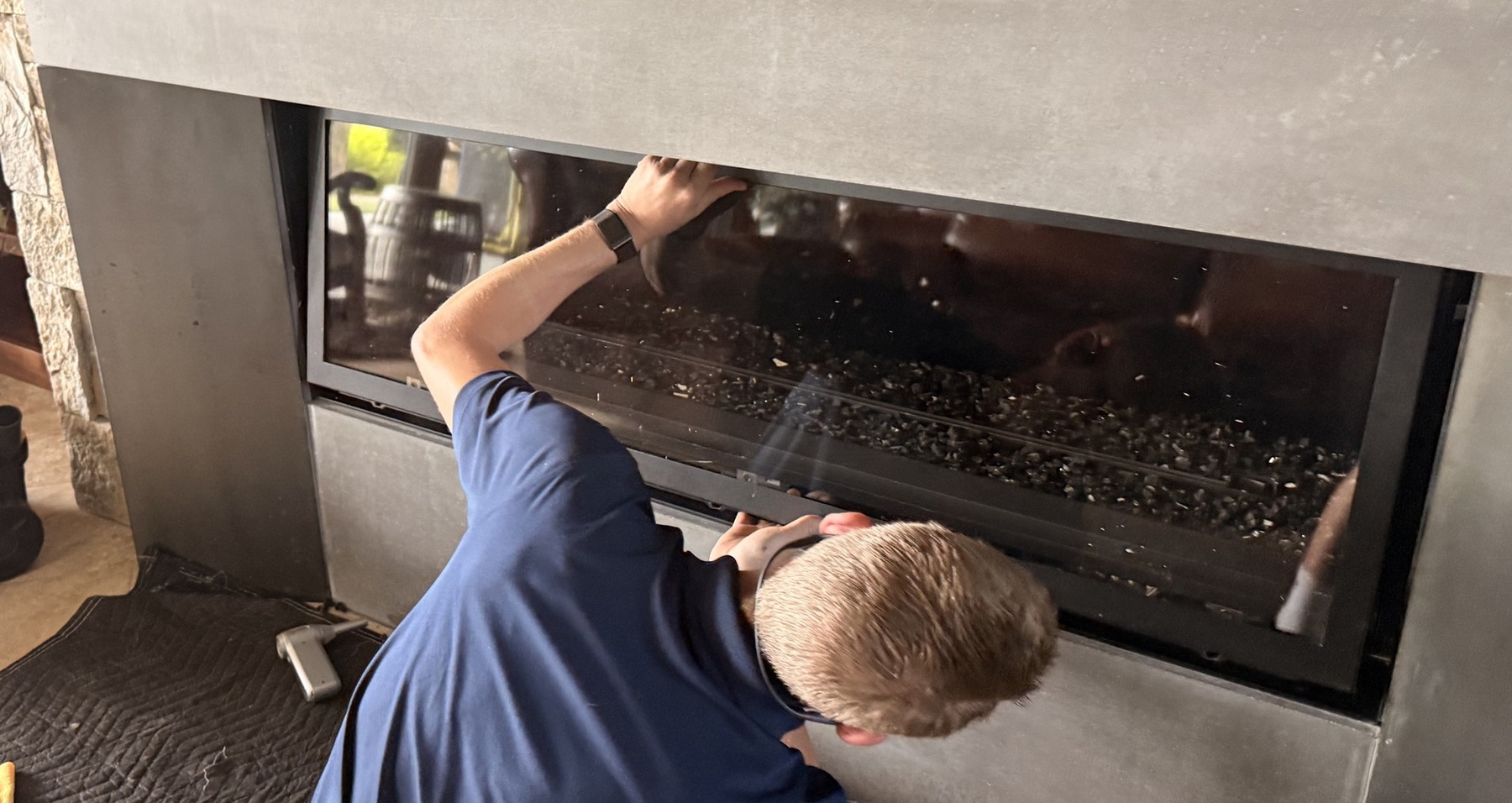 Technician working on a fireplace glass panel