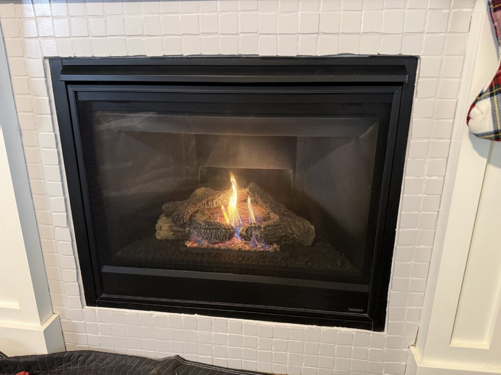Gas fireplace burning in a white-painted brick surround