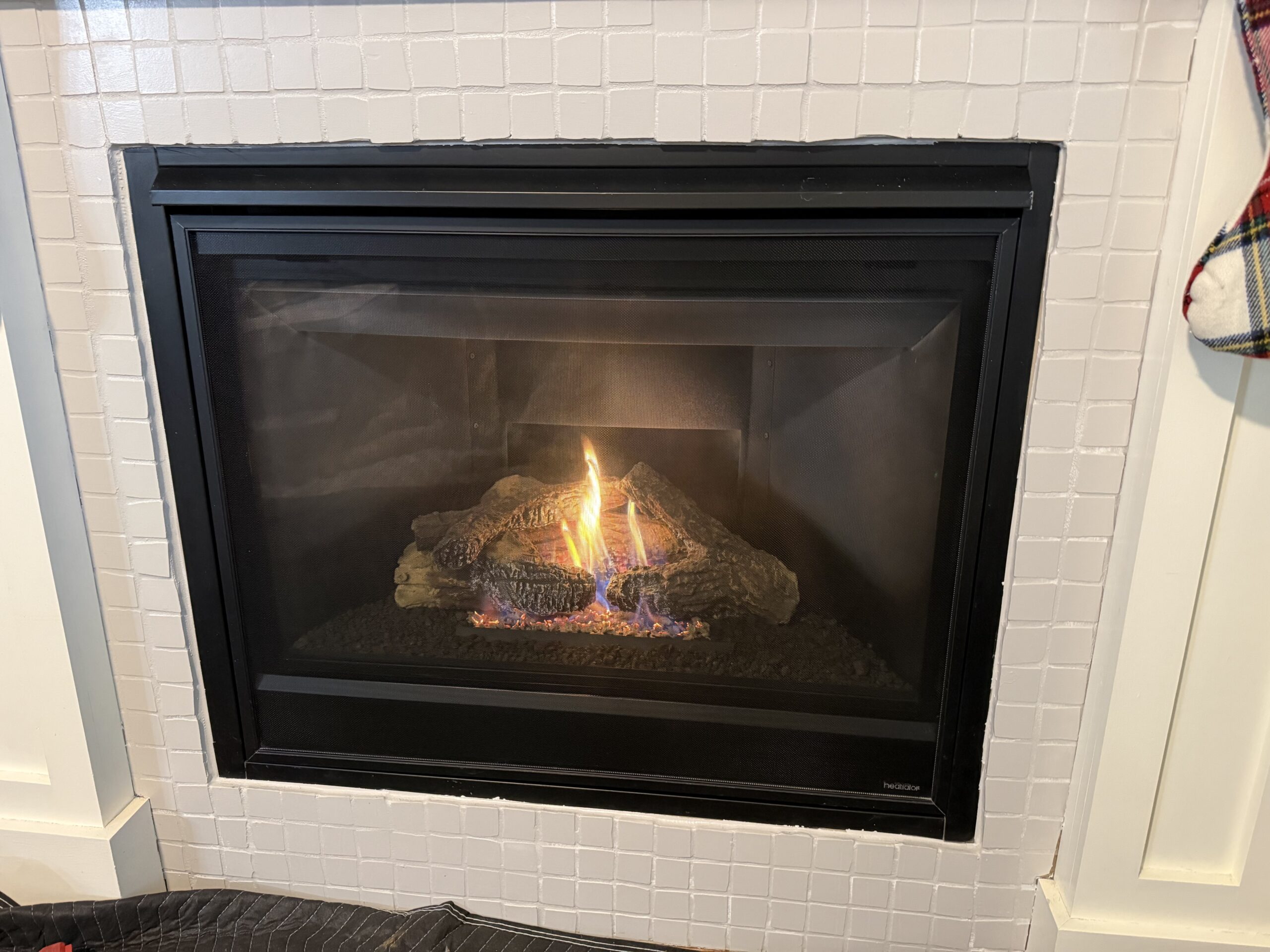 Gas fireplace burning in a white-painted brick surround