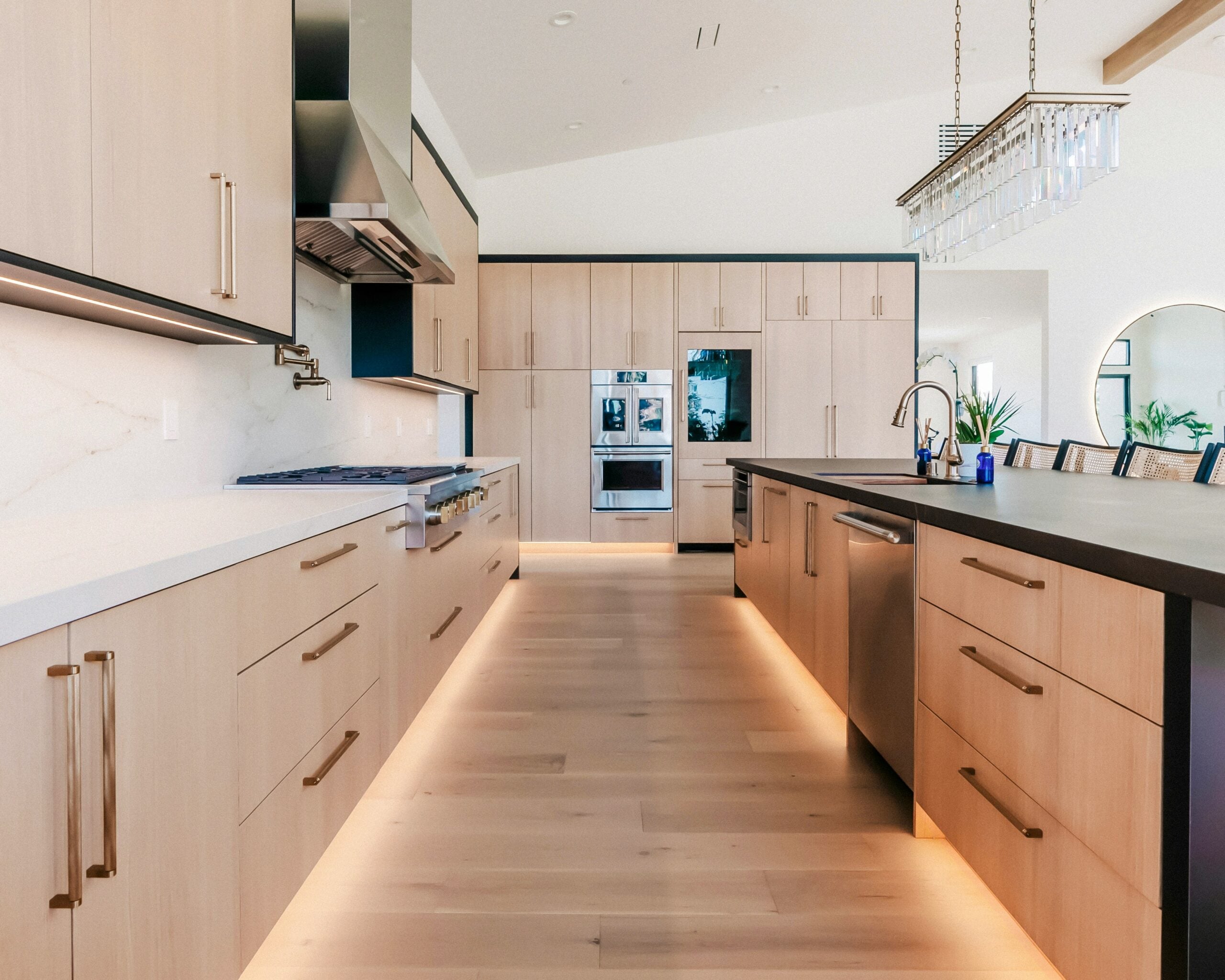Luxury kitchen with light wood cabinetry, integrated appliances and a central island