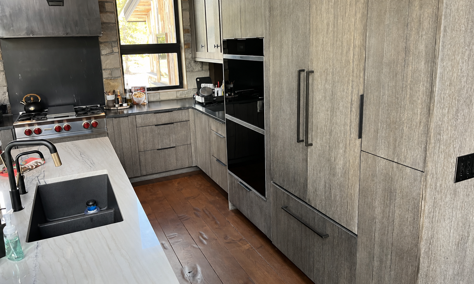 Wolf range and built-in appliances in a gray kitchen